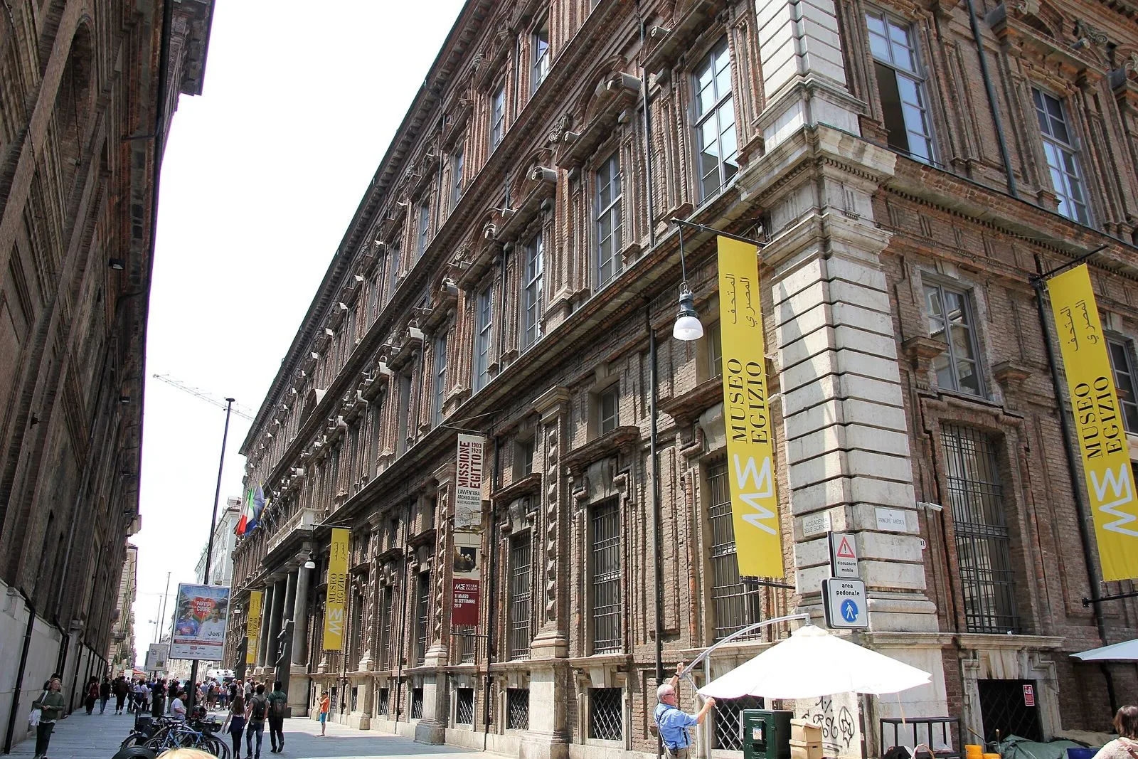 La facciata in mattoni del palazzo che ospita il Museo Egizio in via Accademia delle Scienze, con gli stendardi gialli del museo